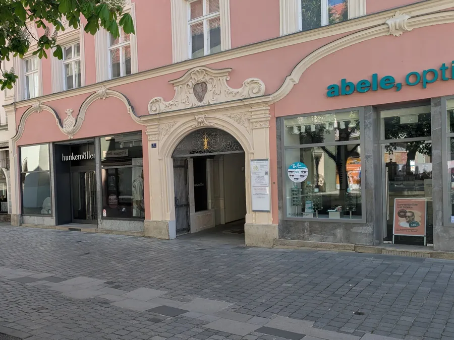 Blick über den Theresienplatz auf das Gebäude Theresienplatz 3 in Straubing mit dem Torbogen als Eingang