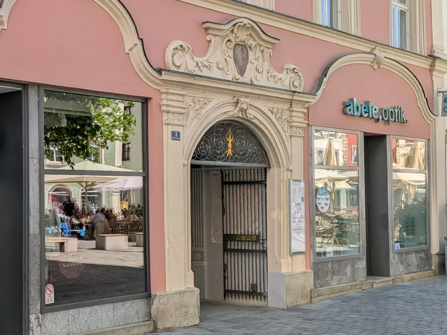 Torbogen mit Hausnummer 3 am Theresienplatz, links und rechts die Ladeneingänge der Nachbarn
